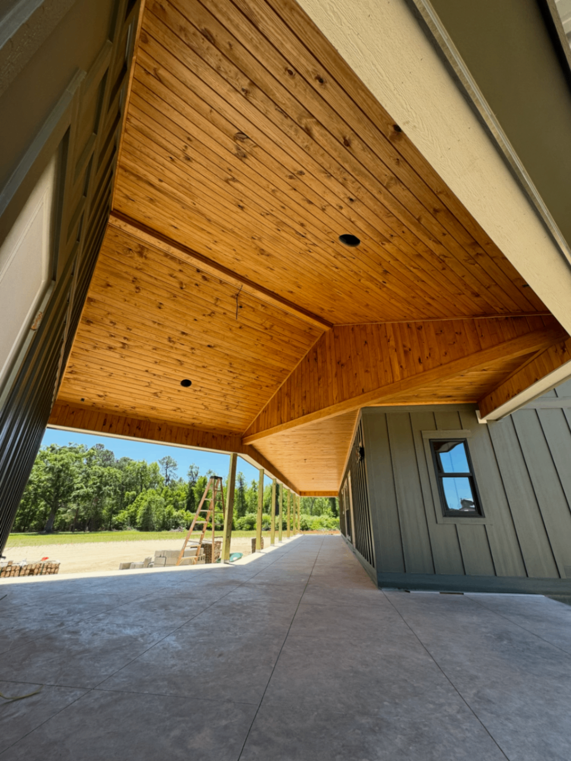Covered porch ceiling finished in warm tongue and groove boards
