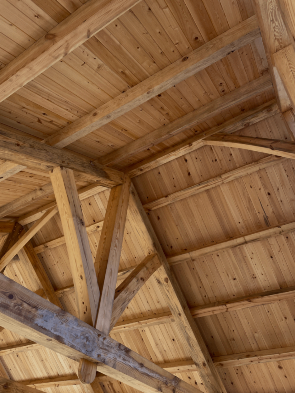 Angled view of heavy timber framing and wood ceiling boards